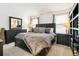Comfortable bedroom featuring a queen size bed, soft carpet, and dresser with large mirror at 13040 W 63Rd Pl # A, Arvada, CO 80004