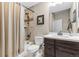 Well-lit bathroom with a shower-tub combo, vanity with dark cabinets and sink with a framed mirror at 6592 Club Villa Rd, Parker, CO 80134