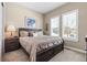 Cozy bedroom featuring large windows, a wooden bed frame, and neutral carpeting at 6592 Club Villa Rd, Parker, CO 80134