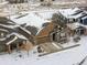 Charming home with a stone and siding exterior, featuring an attached two-car garage and snowy landscape at 6592 Club Villa Rd, Parker, CO 80134