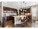 Spacious kitchen with a large center island, dark wood cabinetry, and modern lighting fixtures, ideal for cooking and entertaining at 6592 Club Villa Rd, Parker, CO 80134