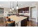 Gourmet kitchen featuring a large island, dark wood cabinets, stainless steel appliances, and modern pendant lighting at 6592 Club Villa Rd, Parker, CO 80134