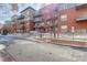 Condominium exterior showcasing brick facade, balconies, and winter landscape at 1438 Little Raven St # 306, Denver, CO 80202