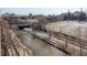 Scenic riverfront view featuring a walking trail, bridge, and distant city skyline, offering a blend of nature and urban living at 1438 Little Raven St # 306, Denver, CO 80202