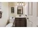 A cozy half-bathroom that includes a decorative mirror, vanity, sink, and toilet at 10987 Cannonade Dr, Parker, CO 80138