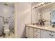 Well-lit bathroom featuring double sinks, a large mirror, and patterned tile flooring at 10987 Cannonade Dr, Parker, CO 80138