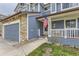 Inviting blue home with a covered front porch and stone accents on the garage at 10987 Cannonade Dr, Parker, CO 80138
