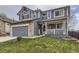 Charming two-story blue home with a stone-accented garage and a welcoming front porch at 10987 Cannonade Dr, Parker, CO 80138