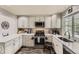 Well-lit kitchen with white cabinets, stainless steel appliances, and mosaic backsplash at 10987 Cannonade Dr, Parker, CO 80138