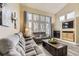 Cozy living room with a fireplace, large windows, and comfortable sofas with a rustic coffee table at 10987 Cannonade Dr, Parker, CO 80138