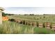 Scenic backyard view with a wooden fence and lush greenery overlooking an open field at 740 Meadowlark Dr, Erie, CO 80516