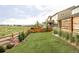 Well-maintained backyard featuring a lush lawn, wood fence, and view of the surrounding neighborhood at 740 Meadowlark Dr, Erie, CO 80516