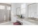 Bright bathroom featuring a spacious glass shower, dual vanities with ample counter space, and a vanity seating area at 740 Meadowlark Dr, Erie, CO 80516