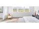 Bright bedroom with neutral tones, three large windows offering ample natural light, and a comfortable seating area at 740 Meadowlark Dr, Erie, CO 80516