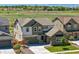 Aerial view showcasing a two-story home, nearby construction, a lush field, and mountain views at 740 Meadowlark Dr, Erie, CO 80516