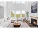 Bright living room with soaring ceilings, gas fireplace, and a large window showcasing a serene view at 740 Meadowlark Dr, Erie, CO 80516