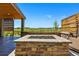 Relaxing outdoor covered patio featuring a brick fire pit and seating area at 740 Meadowlark Dr, Erie, CO 80516