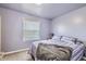 Calm bedroom with striped bedding, a large window, and light purple walls at 4780 Milwaukee St, Denver, CO 80216