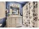 Bright bathroom with royal blue walls, a white vanity, and a shower with a floral curtain at 4780 Milwaukee St, Denver, CO 80216