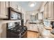 Well-lit kitchen with granite countertops, black appliances, and refinished cabinets at 4780 Milwaukee St, Denver, CO 80216