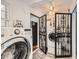 Convenient laundry room with front-load washer and dryer, featuring metal security doors at 4780 Milwaukee St, Denver, CO 80216