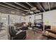 Cozy living room with dark wooden beamed ceiling, a brick fireplace, and comfortable leather seating at 4780 Milwaukee St, Denver, CO 80216