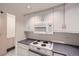 Efficient kitchen featuring white cabinetry and appliances including a microwave and stovetop at 888 N Logan St # 4A, Denver, CO 80203
