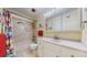 Bright bathroom featuring a shower-tub combination and a vanity with mirror at 663 S Xenon Ct, Lakewood, CO 80228