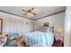 Cozy bedroom with a vintage ceiling fan, comfortable bed, and ample closet space for storage at 663 S Xenon Ct, Lakewood, CO 80228