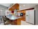 Functional kitchen with wood cabinets, cooktop island, and a white refrigerator at 663 S Xenon Ct, Lakewood, CO 80228