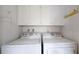 Bright laundry room with white washer, dryer and ample cabinet storage at 663 S Xenon Ct, Lakewood, CO 80228