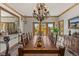 Elegant dining room featuring a chandelier, wood trim, and doors leading to a balcony with mountain views at 24768 Foothills N Dr, Golden, CO 80401