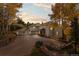 Beautiful home exterior with three-car garage, mature trees, and long driveway at 24768 Foothills N Dr, Golden, CO 80401