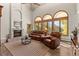 Bright living room showcasing large windows, stone fireplace, and comfortable leather sofas at 24768 Foothills N Dr, Golden, CO 80401