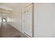 Neutral hallway leading to a bright white door, with wall mounted light fixtures and carpeted floor at 875 E 78Th Ave # 9-2, Denver, CO 80229