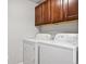 Laundry room showcasing a side-by-side washer and dryer with dark wood cabinetry above at 875 E 78Th Ave # 9-2, Denver, CO 80229