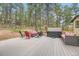 Backyard deck featuring outdoor furniture and a hot tub, surrounded by trees at 4305 Red Rock Dr, Larkspur, CO 80118