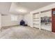 Finished basement with neutral carpet and built-in shelves for storage or display at 4305 Red Rock Dr, Larkspur, CO 80118
