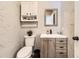 Powder room with rustic vanity, cabinet storage, and textured wall finish at 4305 Red Rock Dr, Larkspur, CO 80118