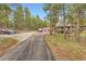 Exterior shot showcasing large driveway and mature trees surrounding the home at 4305 Red Rock Dr, Larkspur, CO 80118
