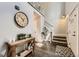 Charming foyer featuring hardwood floors, staircase, stylish decor, and a large decorative wall clock at 4305 Red Rock Dr, Larkspur, CO 80118