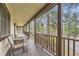 Inviting covered porch with wood floors and views of the surrounding wooded landscape at 4305 Red Rock Dr, Larkspur, CO 80118