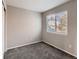 Cozy bedroom featuring new carpet, neutral gray walls, white trim, and a large window at 500 Lashley St # 58, Longmont, CO 80504