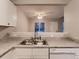 Bright kitchen featuring a stainless steel sink, light countertops, and an opening to the living room at 500 Lashley St # 58, Longmont, CO 80504