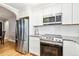 Bright kitchen featuring stainless steel appliances, granite countertops, and white cabinets at 485 S Logan St # 10, Denver, CO 80209