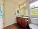 Bathroom featuring a wood cabinet vanity with a granite countertop and a mirror at 16063 E 106Th Ct, Commerce City, CO 80022