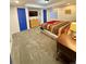Carpeted bedroom with a colorful bedspread, dresser, blue doors, and a window at 16063 E 106Th Ct, Commerce City, CO 80022