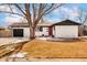 A well-maintained home featuring a dark garage door and a cozy front porch at 966 S Johnson St, Lakewood, CO 80226