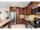 Well-lit kitchen features dark wood cabinets, granite countertops, and stainless steel appliances at 2363 Ranch Dr, Westminster, CO 80234