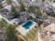 Aerial view of community pool with cover, clubhouse, and surrounding mature trees at 2363 Ranch Dr, Westminster, CO 80234